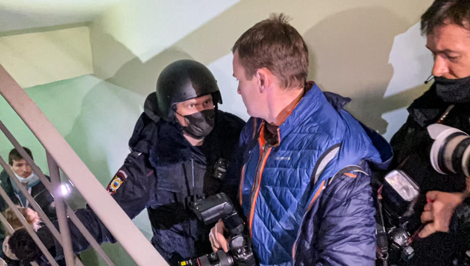 A police officer pushes photographers from a door of the apartment where Oleg Navalny, brother of jailed opposition leader Alexey Navalny, lives in Moscow, Russia, January 27, 2021. / Credit: Mstyslav Chernov/AP