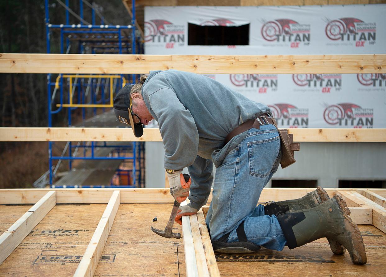 A volunteer hammers a nail into the framing of a wall on the Christmas Jam House Friday Dec. 9, 2022 in Asheville Area Habitat for Humanity's growing West Asheville neighborhood. The nonprofit will receive $1.3 million in emergency repair grants to agencies such as Habitat from Buncombe County.