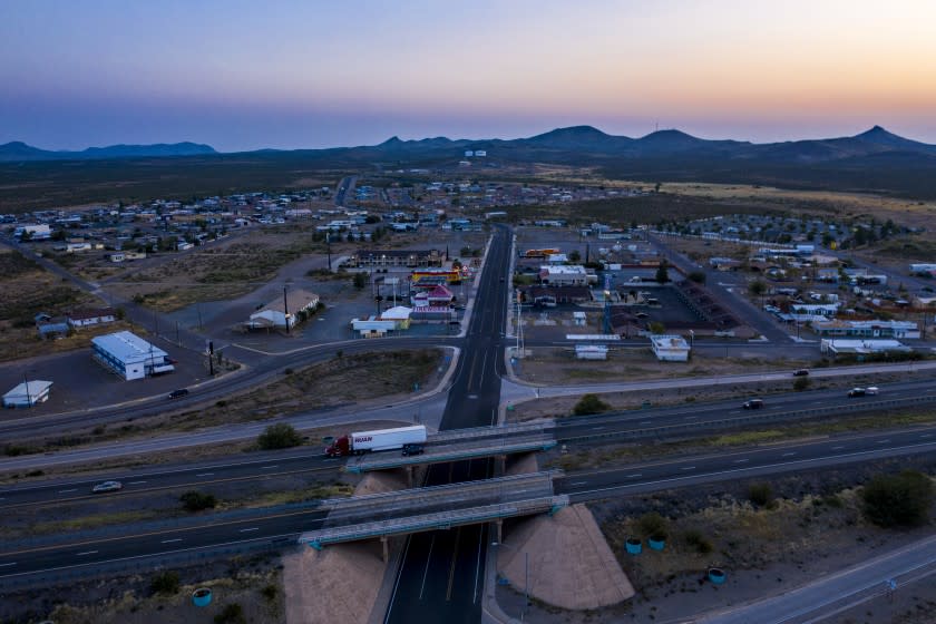 LORDSBURG, NM - SEPTEMBER 20: A truck rolls past the Main St. exit on Interstate 10, dividing the rural town of Lordsburg, NM on Sunday, Sept. 20, 2020. Tax revenues have plummeted as fewer monists are stopping in for gas, food or a few hours of sleep. (Brian van der Brug / Los Angeles Times)