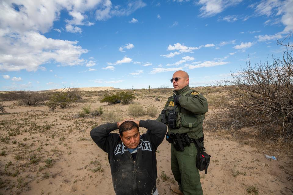 Border Patrol agent Orlando Marrero-Rubio detains two migrants who had entered the U.S. without proper documentation in Sunland Park, New Mexico, in March.