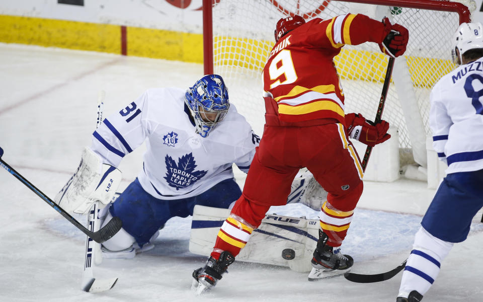 Toronto Maple Leafs goalie Frederik Andersen, left, makes a save on Calgary Flames' Matthew Tkachuk during the second period of an NHL hockey game, Tuesday, Jan. 26, 2021 in Calgary, Alberta. (Jeff McIntosh/The Canadian Press via AP)