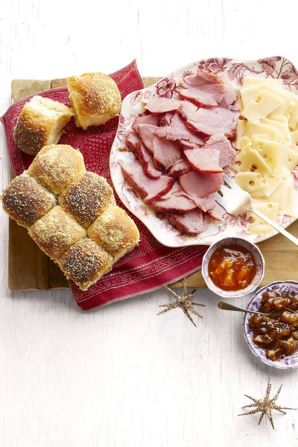 honey glazed ham and checkerboard rolls with sliced cheese and jam in bowl