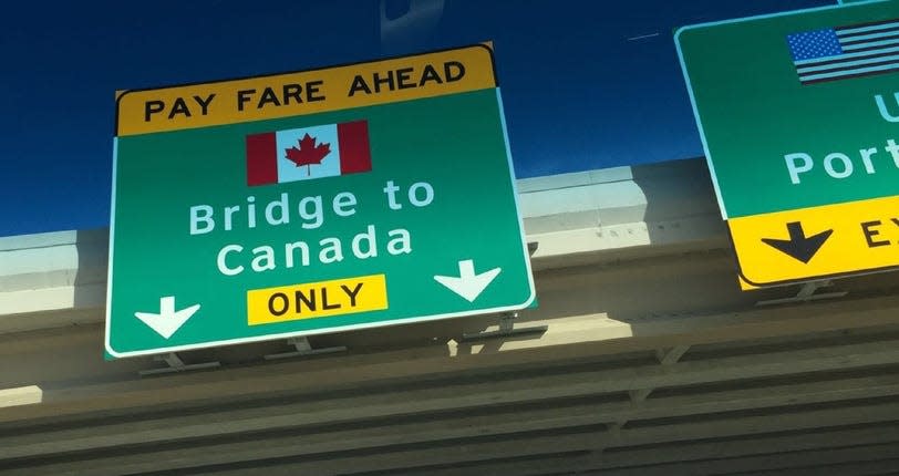 Sign posted on a freeway overpass pointing toward bridge to Canada.