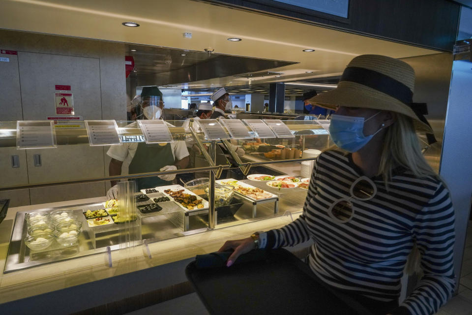 A passenger wears a face mask in a restaurant of the MSC Grandiosa cruise ship in Civitavecchia, near Rome, Wednesday, March 31, 2021. MSC Grandiosa, the world's only cruise ship to be operating at the moment, left from Genoa on March 30 and stopped in Civitavecchia near Rome to pick up more passengers and then sail toward Naples, Cagliari, and Malta to be back in Genoa on April 6. For most of the winter, the MSC Grandiosa has been a lonely flag-bearer of the global cruise industry stalled by the pandemic, plying the Mediterranean Sea with seven-night cruises along Italy’s western coast, its major islands and a stop in Malta. (AP Photo/Andrew Medichini)