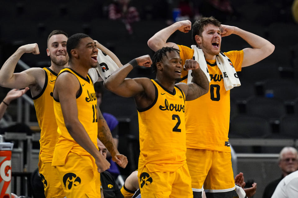 Iowa's Tony Perkins (11), Joe Toussaint (2) and Iowa forward Filip Rebraca (0) celebrate on the bench in the second half of an NCAA college basketball game against Northwestern at the Big Ten Conference tournament in Indianapolis, Thursday, March 10, 2022. Iowa defeated Northwestern 112-76. (AP Photo/Michael Conroy)