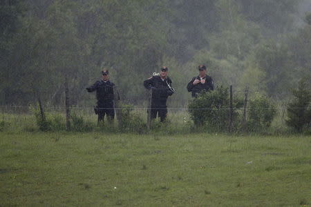 Law enforcement officers search a field near Willsboro, New York, June 9, 2015. REUTERS/Chris Wattie