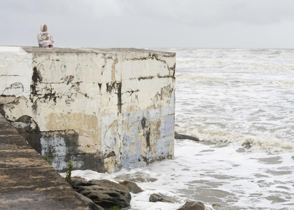 Megan Johnston toma café mientras está sentada en el malecón de Galveston, Texas, el miércoles 19 de junio de 2024. (Jason Fochtman/Houston Chronicle via AP)