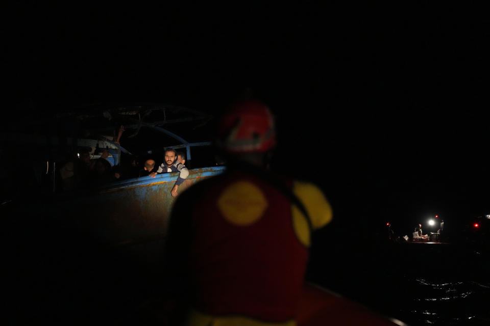 Migrants wait to be rescued by members of the Spanish NGO Open Arms lifeguard during a rescue operation at the Mediterranean sea, early Sunday, Sept. 18, 2022. Around 200 migrants from Syria and Africa countries were rescued by NGO Open Arms crew members. (AP Photo/Petros Karadjias)