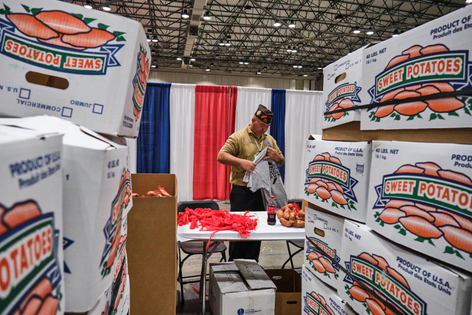 Michael Braman checks out a t-shirt he was given for his efforts in helping to bag up sweet potatoes at the VFW's Big 10 Conference Caucus in Kansas City, Mo., on July 16, 2022. (Dominick Williams for NBC News)