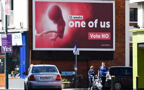 Pedestrians pass a billboard urging a 'no' vote in the Irish referendum - Credit: AFP