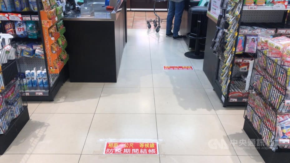 圖為百貨超市地板，貼上提醒標語，請排隊民眾至少保持1公尺距離。(資料照)
