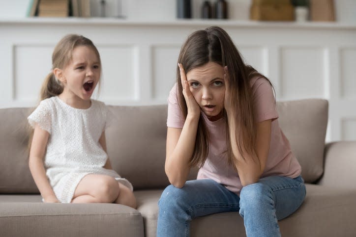 Stressed exhausted mother from screaming stubborn kid tantrum