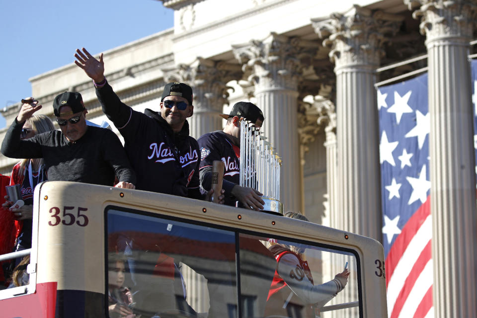 Washington Nationals manager Dave Martinez (4) waves to fans during a parade to celebrate the team's World Series baseball championship over the Houston Astros, Saturday, Nov. 2, 2019, in Washington. (AP Photo/Patrick Semansky)