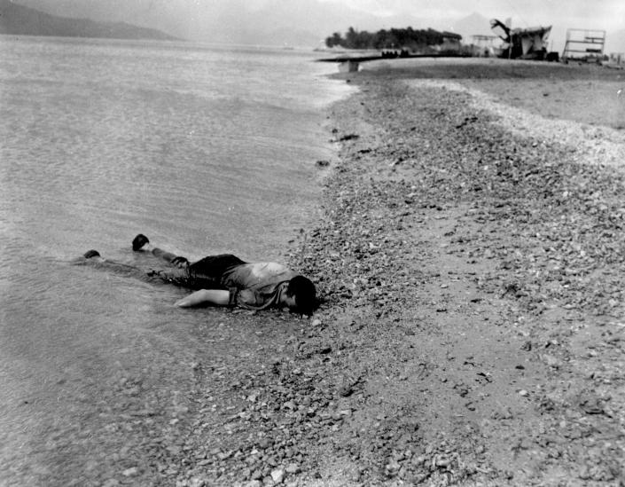 <p>The body of a sailor killed during the Japanese air attack at Naval Air Station Kanoehe Bay lies on the shoreline at Pearl Harbor on Dec. 7, 1941. (U.S. Navy/National Archives/Handout via Reuters) </p>