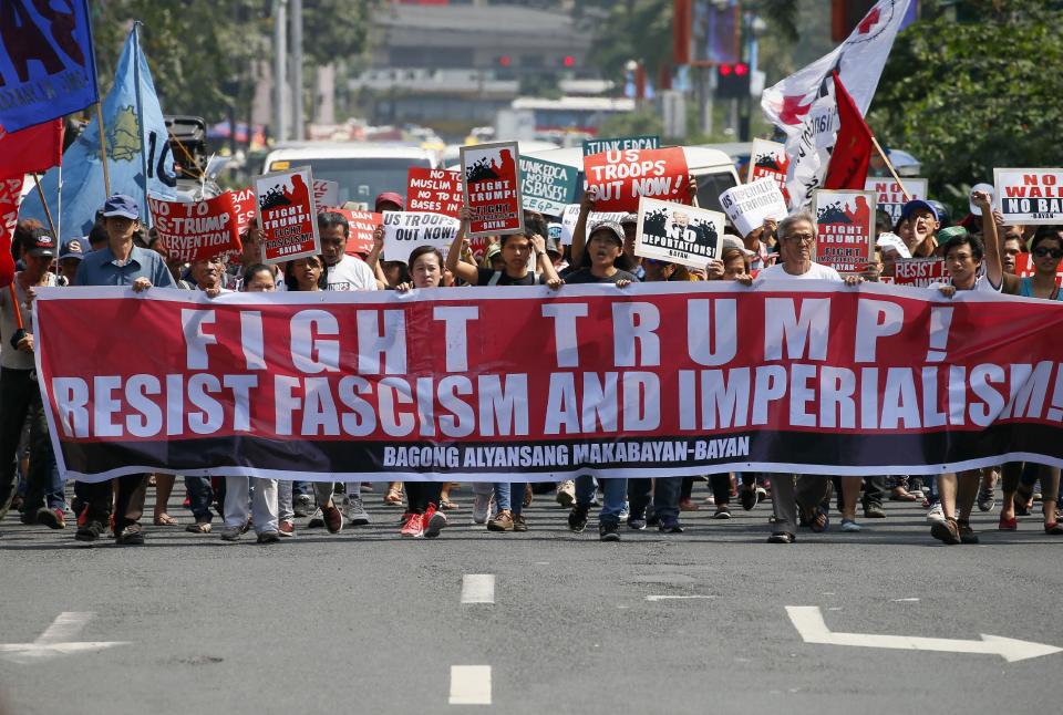 Prtoesters march with placards in front of the U.S. Embassy to protest U.S. President Donald Trump's recent anti-immigration policies, Saturday, Feb. 4, 2017, in Manila, Philippines. The protest also marked the Feb. 4, 1899 Filipino-American War. (AP Photo/Bullit Marquez)