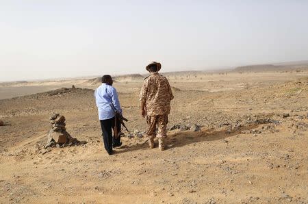 A Libyan soldier (R) and a member of a security unit patrol the desert border between Libya and Algeria May 29, 2014. REUTERS/Ahmed Jadallah