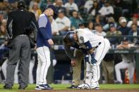 Sep 8, 2018; Seattle, WA, USA; Seattle Mariners first baseman Robinson Cano (22) is assessed by a team trainer (center) and manager Scott Servais (left) after being hit by a pitch against the New York Yankees during the ninth inning at Safeco Field. Mandatory Credit: Joe Nicholson-USA TODAY Sports