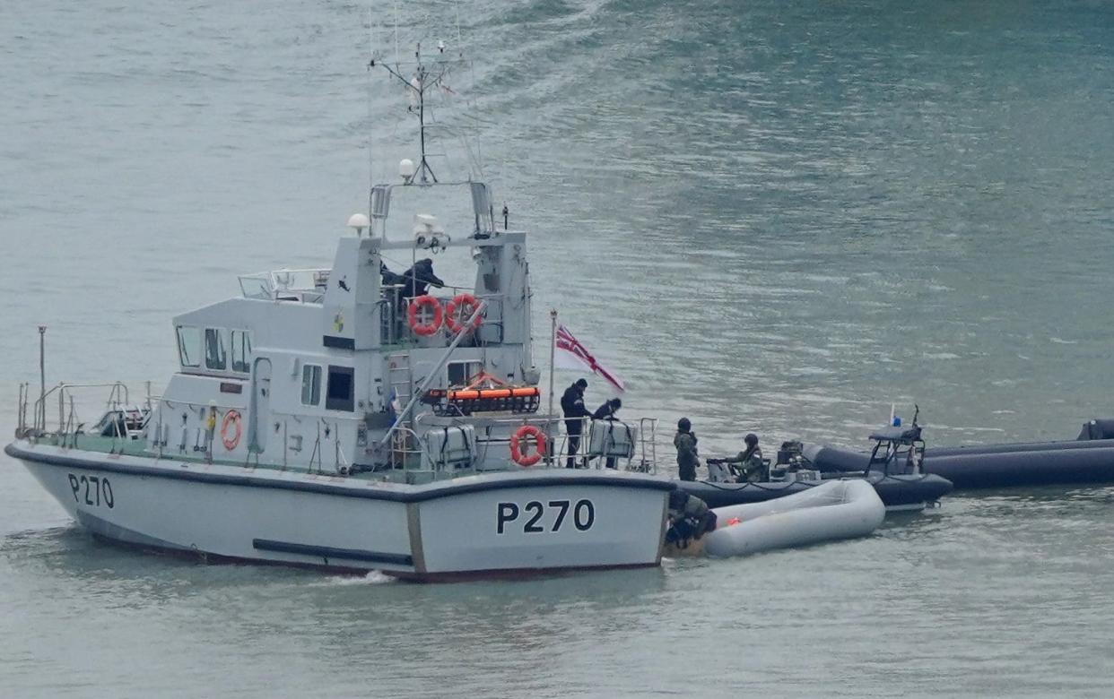 A Royal Navy vessel tows boats used by migrants crossing the Channel earlier this year - Gareth Fuller/PA Wire