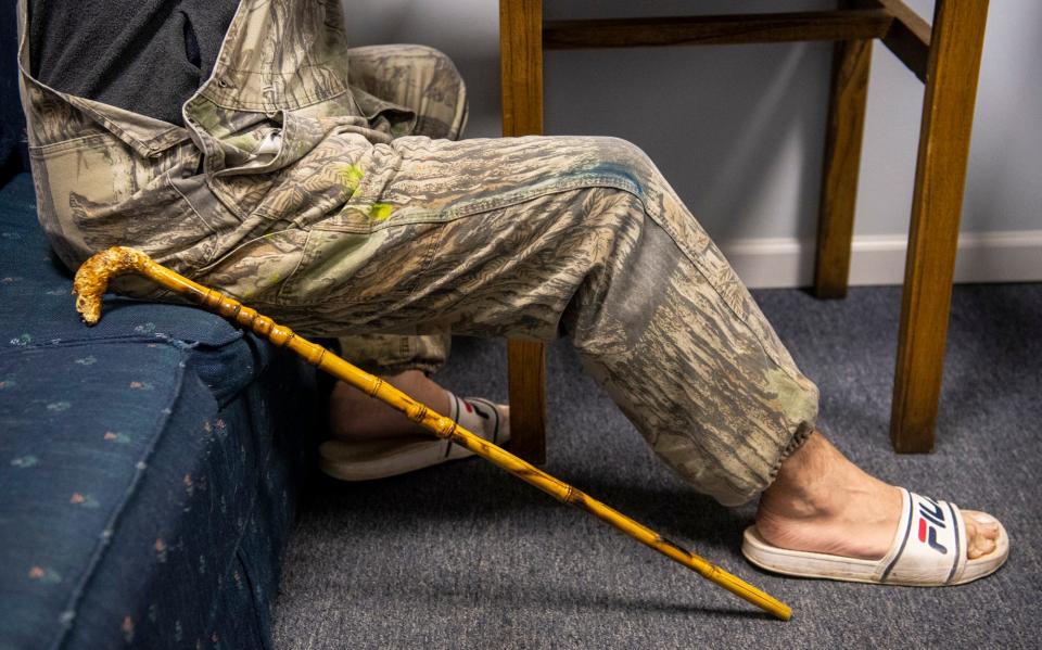 Nathaniel Reed's cane rests by his side during his meeting with Katie Norris, executive director for Hotels For Homeless, as they try to find housing for the night on Tuesday, Nov. 29, 2022.