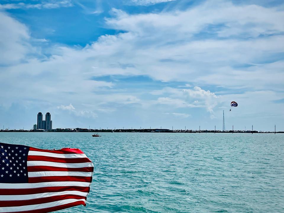 An American flag in front of the water.