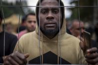 A migrant stands by the fence at the newly built refugee camp in the Rudninkai military training ground, some 38km (23,6 miles) south from Vilnius, Lithuania, Wednesday, Aug. 4, 2021. The Red Cross warned Wednesday that Lithuania's decision to turn away immigrants attempting to cross in from neighboring Belarus does not comply with international law. Lithuania, a member of the European Union, has faced a surge of mostly Iraqi migrants in the past few months. Some 4,090 migrants, most of them from Iraq, have crossed this year from Belarus into Lithuania. (AP Photo/Mindaugas Kulbis)