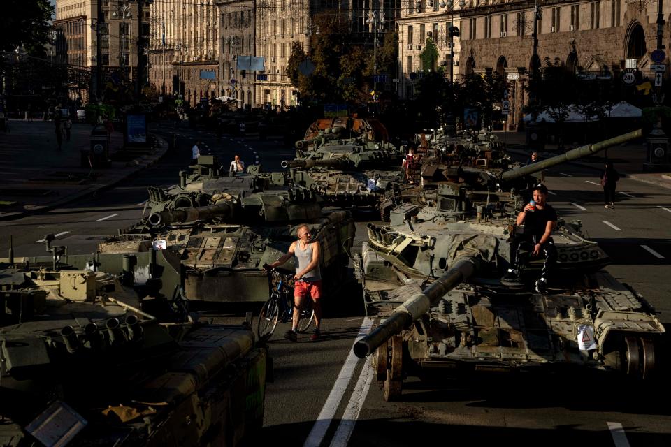 People walk around destroyed Russian military vehicles installed in downtown Kyiv, Ukraine, for the country's Independence Day on Wednesday. Kyiv authorities have banned mass gatherings through Thursday for fear of Russian missile attacks. Wednesday also marked six months since the Russian invasion began.