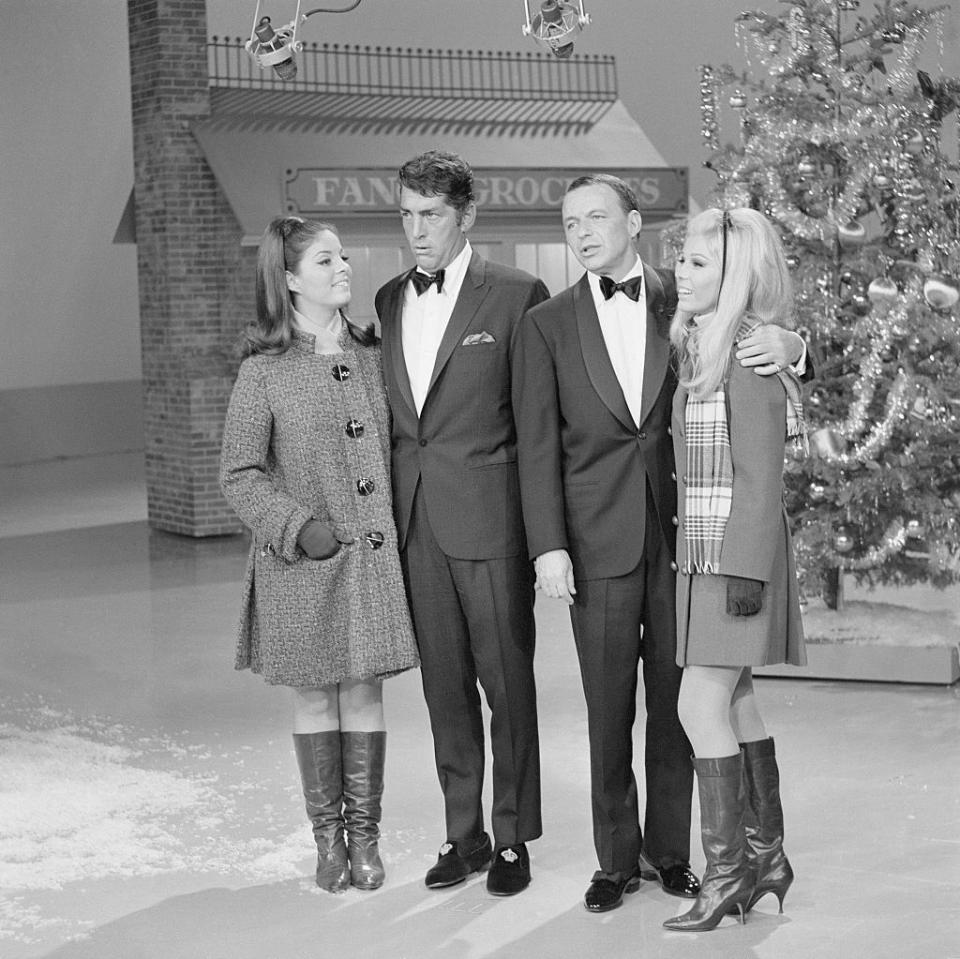 <p>Longtime pals, Dean Martin and Frank Sinatra, are joined by their daughters, Gail Martin and Nancy Sinatra, for a Christmas segment on <em>The Dean Martin Show. </em>Afterwards other members of their families joined in on the holiday fun.</p>