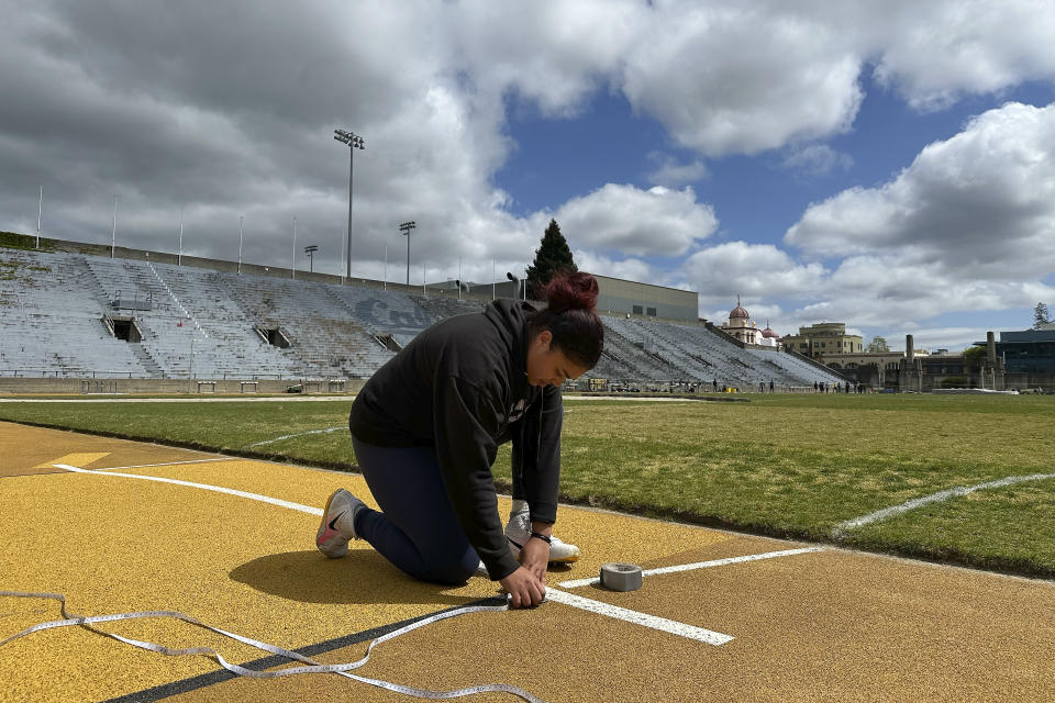 Carolina Visca sets up measuring tape before throwing during a practice in Berkeley, Calif., Friday, April 12, 2024. (AP Photo/Janie McCauley)