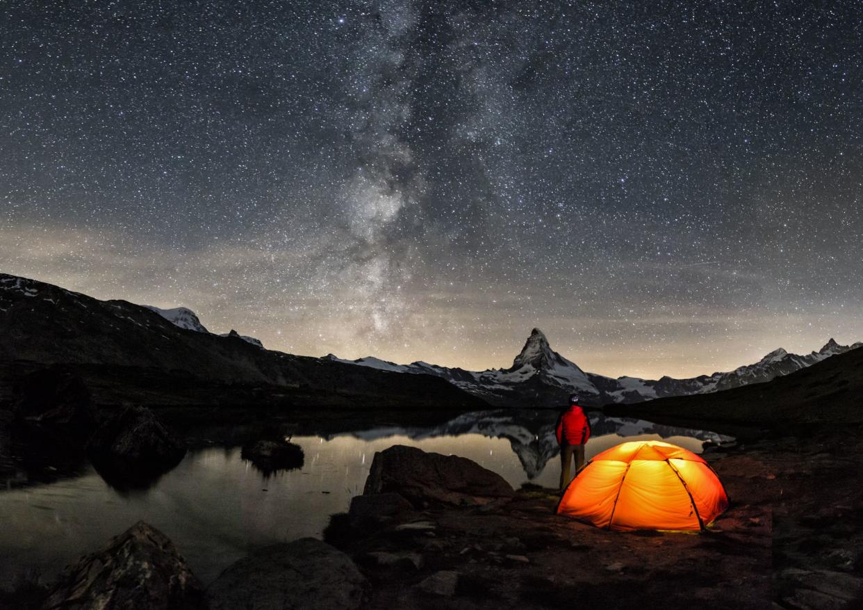 An illuminated tent under Milky Way at Matterhorn in Switzerland