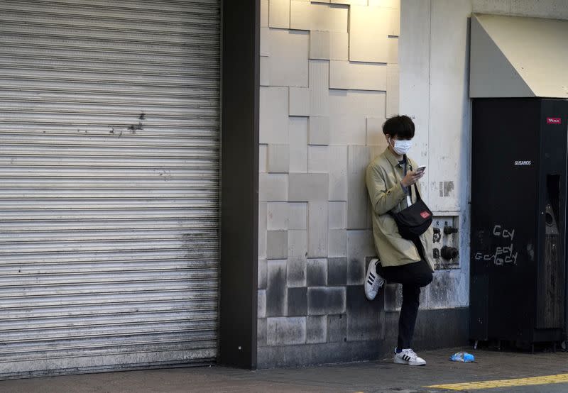 Man wearing a protective mask uses a mobile phone in Tokyo