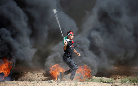 A Palestinian demonstrator uses a sling to hurl stones at Israeli troops during a protest marking al-Quds Day, (Jerusalem Day), at the Israel-Gaza border, east of Gaza City June 8, 2018. REUTERS/Mohammed Salem