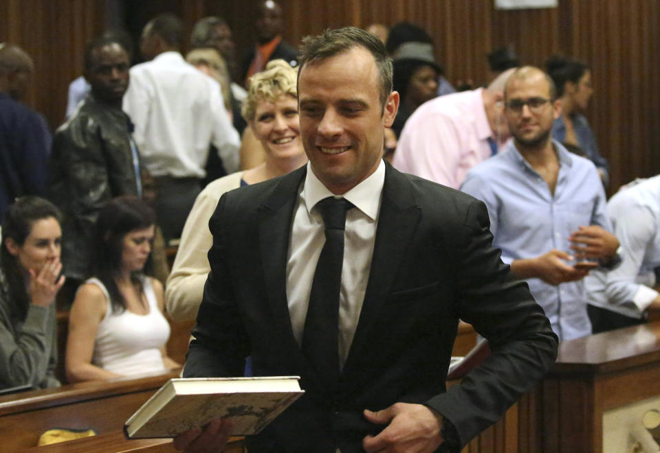 FILE - Oscar Pistorius, center, leaves a courtroom of the High Court in Pretoria, South Africa, Tuesday Dec. 8, 2015. Pistorius could be granted parole on Friday, Nov. 24, 2023 after nearly 10 years in prison for killing his girlfriend. The double-amputee Olympic runner was convicted of a charge comparable to third-degree murder for shooting Reeva Steenkamp in his home in 2013. He has been in prison since late 2014. (AP Photo/Siphiwe Sibeko, Pool, File)