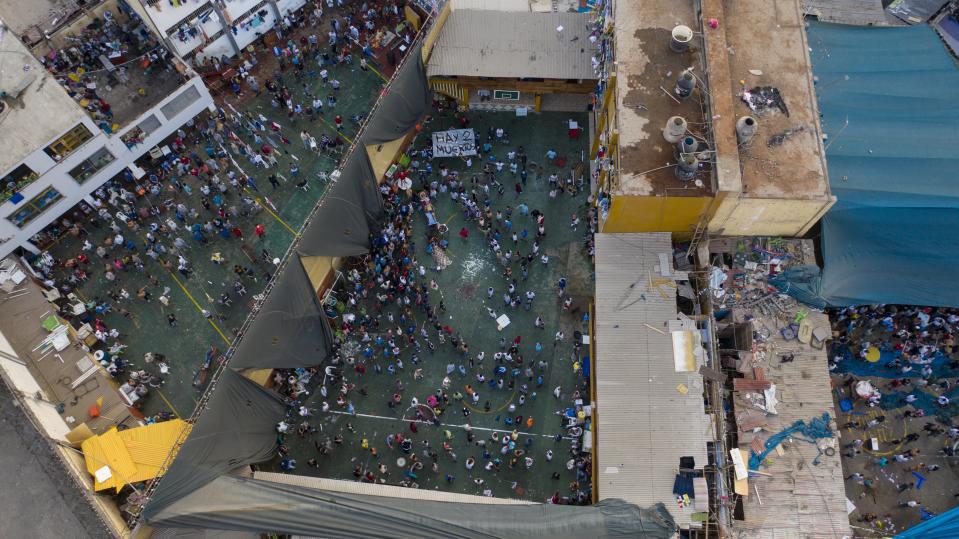 Inmates gather around the corpses of other inmates during a prison riot in Miguel Castro Castro prison, in Lima, Peru, Monday, April 27, 2020. Peru's prison agency reported that three prisoners died from causes still under investigation after a riot at the prison. Inmates complain authorities are not doing enough to prevent the spread of coronavirus inside the prison. (AP Photo/Rodrigo Abd)