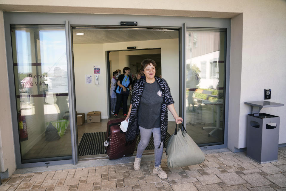 A nurse leaves the Vilanova nursing home in Corbas, near Lyon, central France, Monday, May 4, 2020. For 47 days and nights, staff and the 106 residents of the Vilanova nursing home on the outskirts of the east-central city of Lyon waited out the coronavirus storm together, while the illness killed tens of thousands of people in other homes across Europe, including more than 9,000 in France. Because staff and residents were locked in together, Vilanova didn't have to confine people to their rooms like other homes to shield them from the risk of infection brought in from outside. (AP Photo/Laurent Cipriani)