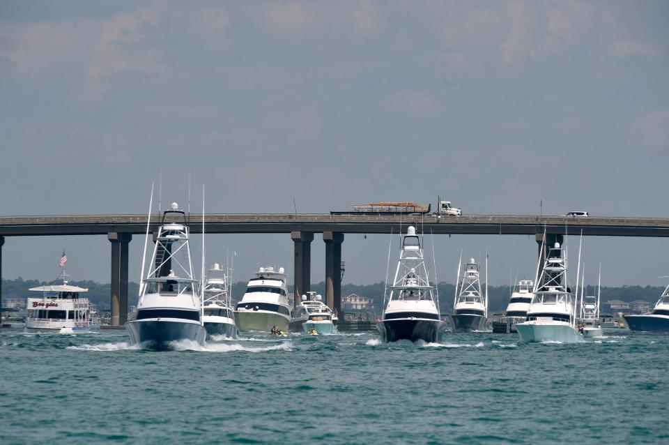 Fishing boats make their way under the Marler Bridge and out Destin's East Pass at the start of the 2020 Emerald Coast Blue Marlin Classic.