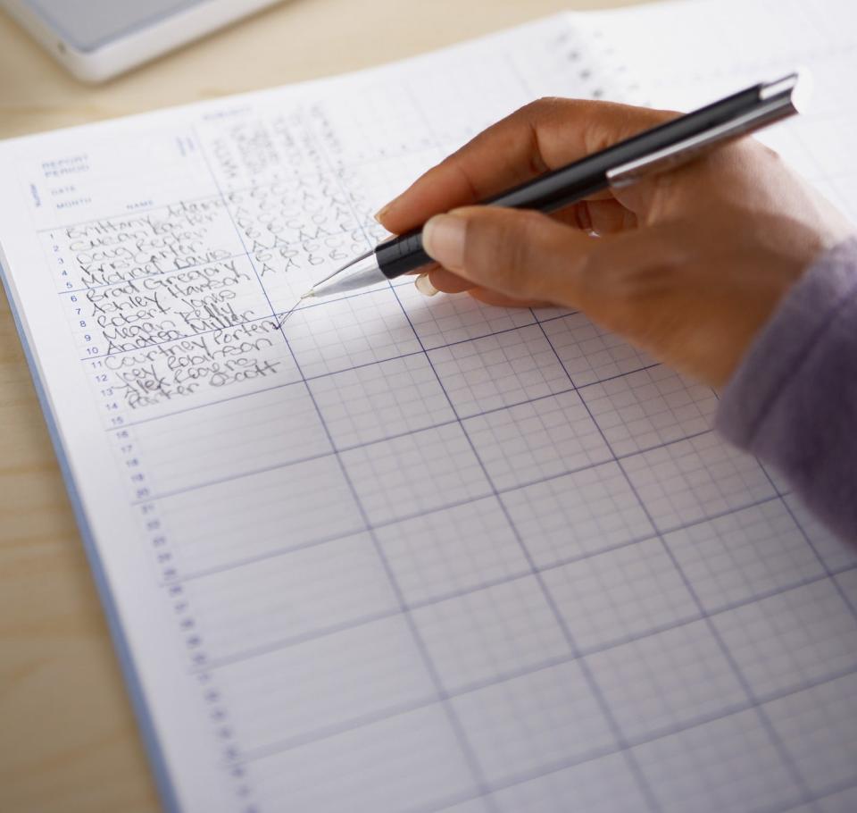 A teacher using a grade book