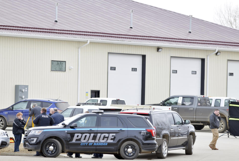 Mandan, N.D. Police Deputy Chief Lori Flaten, left, and other law enforcement personnel stand outside the scene on the south side the RJR Maintenance and Management property in Mandan, N.D., Monday, April 1, 2019. (Mike McCleary/The Bismarck Tribune via AP)