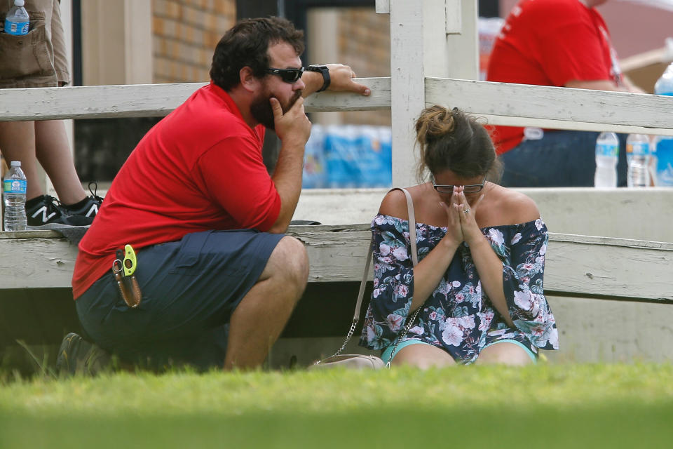 <p>A woman prays in the grass outside the Alamo Gym where parents wait to reunite with their kids following a shooting at Santa Fe High School Friday, May 18, 2018, in Santa Fe, Texas. (Photo: Michael Ciaglo/Houston Chronicle via AP) </p>