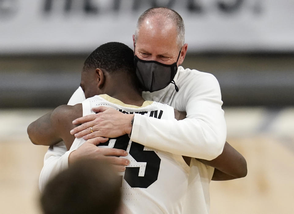 Colorado coach Tad Boyle, back, hugs guard McKinley Wright IV as Wright was introduced as one of the team's graduating seniors, following the team's NCAA college basketball game against UCLA on Saturday, Feb. 27, 2021, in Boulder, Colo. (AP Photo/David Zalubowski)