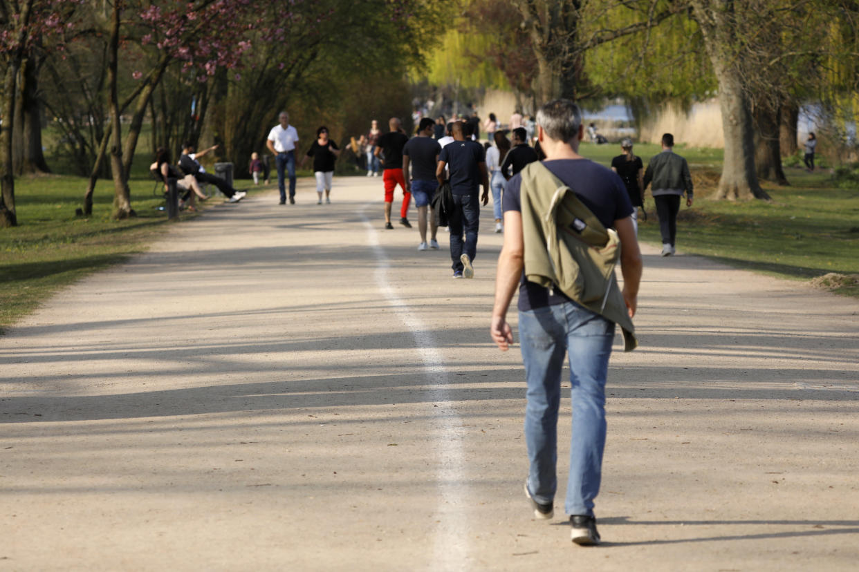 People walk along the city Alster lake in the northern German city of Hamburg on Easter Sunday, on April 12, 2020 amid the spread of the novel coronavirus COVID-19. - The Hamburg administration has divided the popular Alster-routes into directional routes in order to comply with the applicable distance rules. (Photo by MORRIS MAC MATZEN / AFP) (Photo by MORRIS MAC MATZEN/AFP via Getty Images)