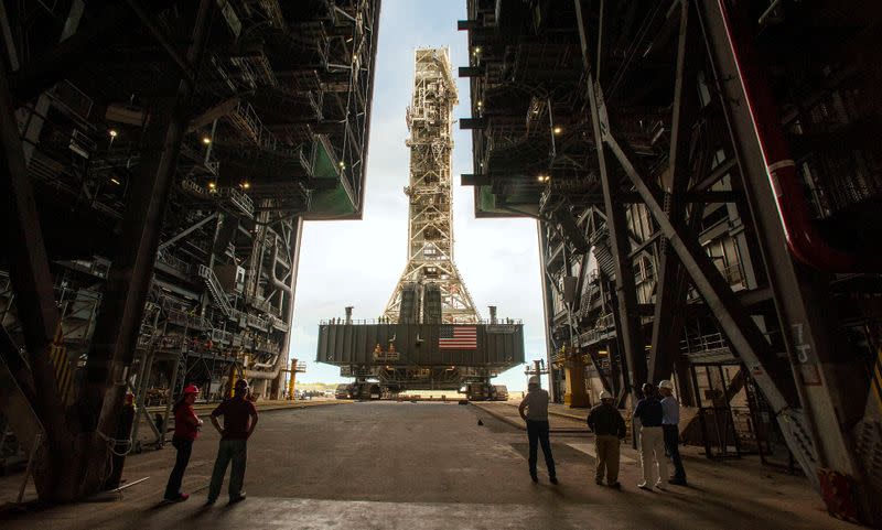 FILE PHOTO: NASA employees look on as the Artemis launch tower rolls back from Pad 39B inside Bay 3 of the Vehicle Assembly Building at the Kennedy Space Center before Hurricane Dorian makes landfall