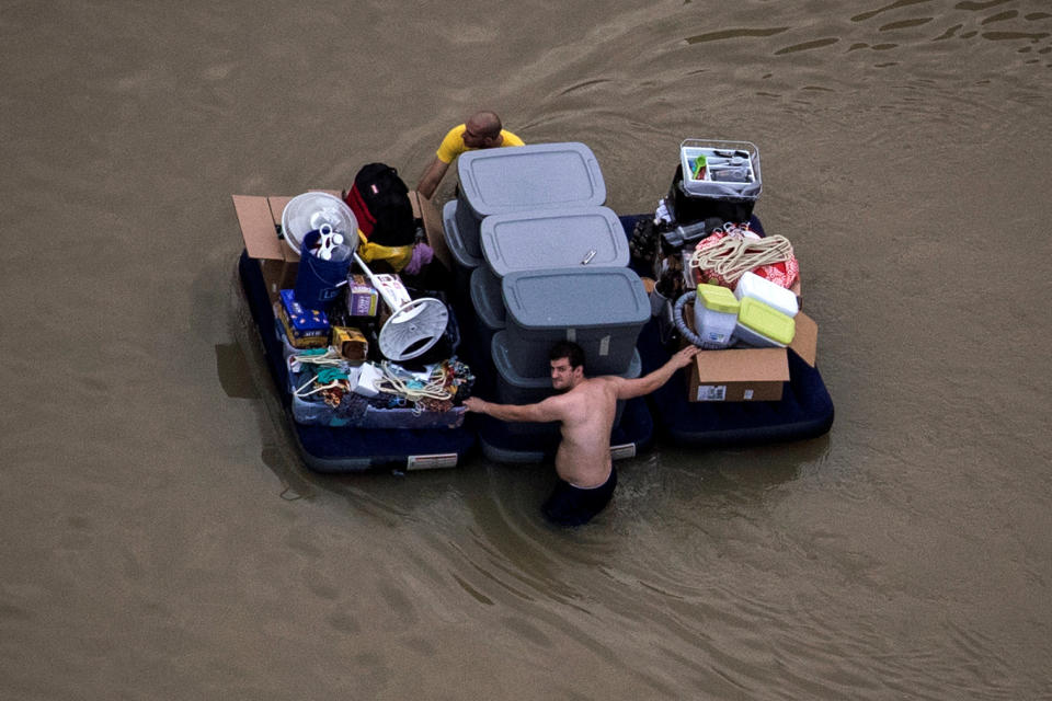 <p>Residents wade with their belongings through flood waters brought by Tropical Storm Harvey in Northwest Houston, Texas, Aug. 30, 2017. (Photo: Adrees Latif/Reuters) </p>