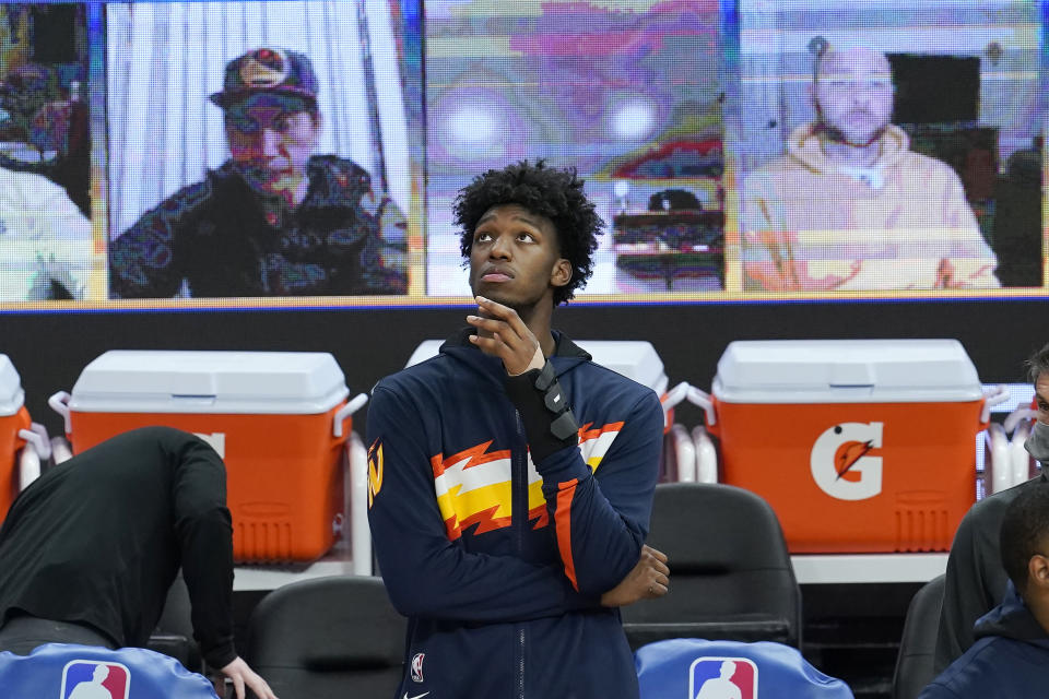 Injured Golden State Warriors center James Wiseman watches players warm up for an NBA basketball game between the Warriors and the Boston Celtics in San Francisco, Tuesday, Feb. 2, 2021. (AP Photo/Jeff Chiu)