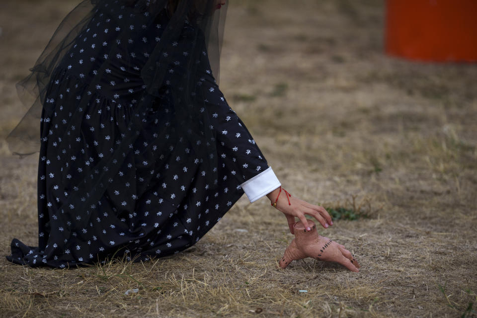 A child picks up a toy depicting Thing Addams, the fictional movie character, at the West Side Hallo Fest, a Halloween festival in Bucharest, Romania, Friday, Oct. 27, 2023. Tens of thousands streamed last weekend to Bucharest's Angels' Island peninsula for what was the biggest Halloween festival in the Eastern European nation since the fall of Communism. (AP Photo/Andreea Alexandru)