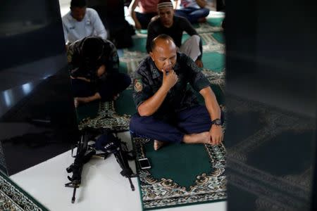 REFILE - ADDING EID AL-FITR PRAYERS A Philippines police officer performs Eid al-Fitr prayers in a mosque inside city hall compound in as government forces continue their assault against insurgents from the Maute group, who have taken over large parts of Marawi City , Philippines June 25, 2017. REUTERS/Jorge Silva