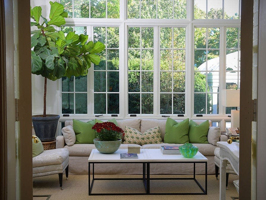 The Solarium in the vice president's official residence. A white sectional decorated with green pillows set under large windows.