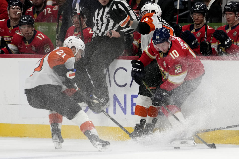 Philadelphia Flyers center Scott Laughton (21) and Florida Panthers right wing Vladimir Tarasenko (10) go fro the puck during the first period of an NHL hockey game, Thursday, March 7, 2024, in Sunrise, Fla. (AP Photo/Lynne Sladky)