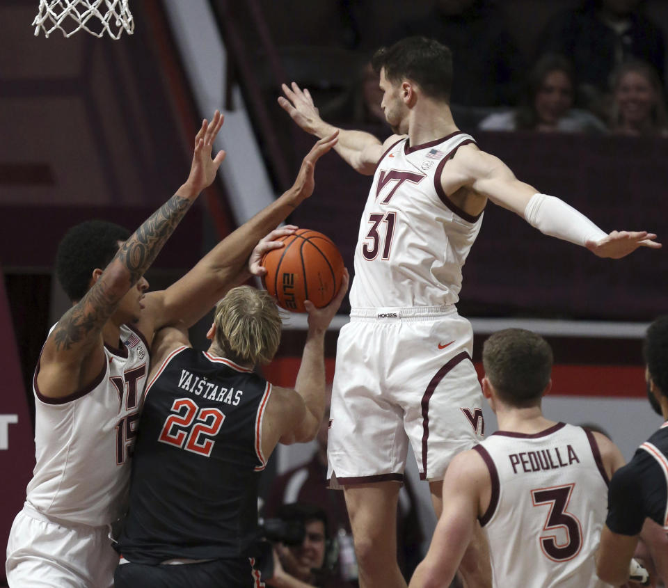 Campbell's Laurynas Vaistaras (22) is fouled while defended by Virginia Tech's Lynn Kidd (15) and Robbie Beran (31) during the first half of an NCAA college basketball game Wednesday, Nov. 15, 2023, in Blacksburg, Va. (Matt Gentry/The Roanoke Times via AP)
