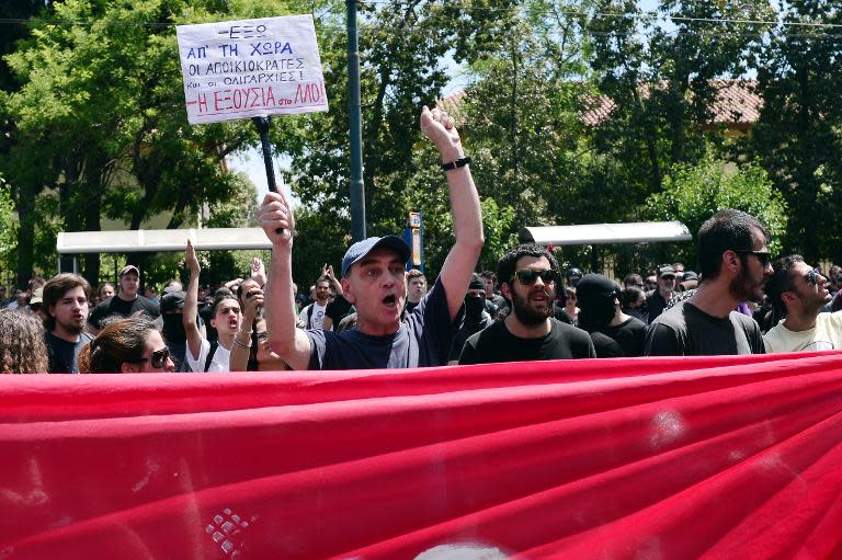 A protester shouts slogans carrying placard reading "power to the people" during a protest march by anti-establishment protesters towards the German embassy in Athens on May 23, 2015