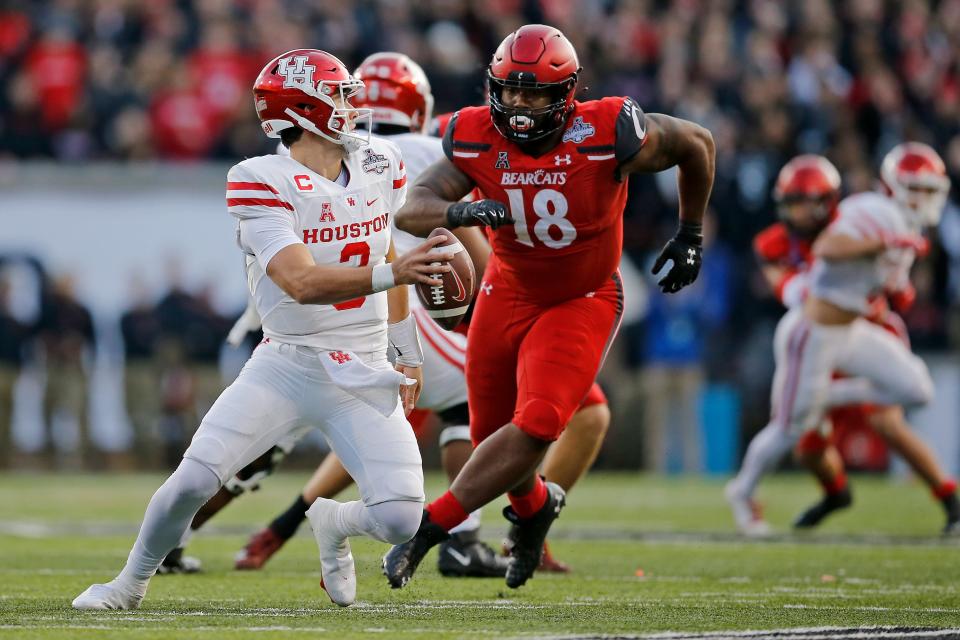 Cincinnati defensive lineman Jowon Briggs (18) led the Bearcats to a win over Houston quarterback Clayton Tune (3) and the Cougars in the 2021 American Athletic Conference Championship football game last season at Nippert Stadium. Briggs will look to lead the Bearcats past visiting Indiana on Saturday.